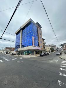 a large building with blue windows on a city street at Hotel Oceanik in Manta