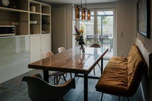 a kitchen and dining room with a wooden table and chairs at Ferienhaus Maarwinkel in Gillenfeld