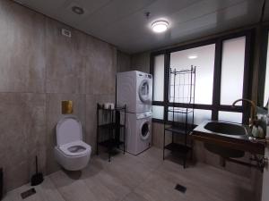 a bathroom with a washing machine and a toilet at Yalarent C Kinneret Amazing Apartments in Migdal +44 photos