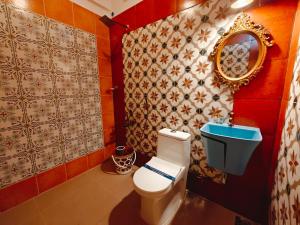 a bathroom with a toilet and a mirror at Chola Heritage Resort in Kāraikkudi