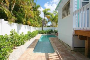 una piscina en un patio trasero con una valla blanca en 231 Pearl Street, short walk to the beach, en Fort Myers Beach