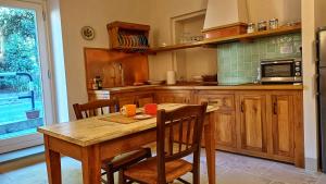 a kitchen with a wooden table and a table and chairs at Il Sensalino in San Donato in Poggio