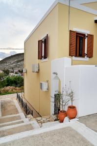 een gebouw met twee ramen en twee potplanten bij Voula's Traditional House in Meyisti