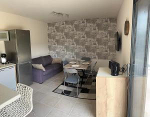 a kitchen and living room with a couch and a table at Charmant logement avec terrasse et parking sécurisé in Arpajon-sur-Cère +2 photos