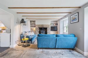 a living room with a blue couch and a fireplace at Treovis Farm in Callington +35 photos