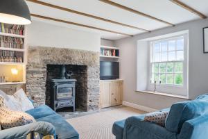 a living room with a blue couch and a fireplace at Treovis Farm in Callington