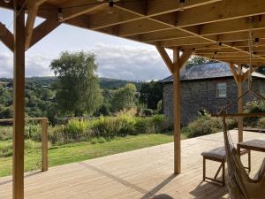 a wooden deck with a view of a house at Treovis Farm in Callington