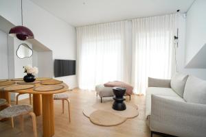 ein Wohnzimmer mit einem Tisch und einem Sofa in der Unterkunft N i d e l ê in Nida
