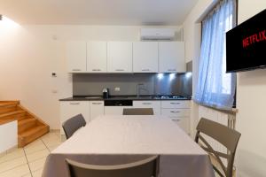 a kitchen with a table and chairs in a room at Porta Garibaldi Vicolo S Floriano in Iesi