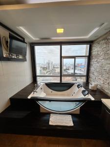 a bath tub in a bathroom with a large window at Hotel Oceanik in Manta