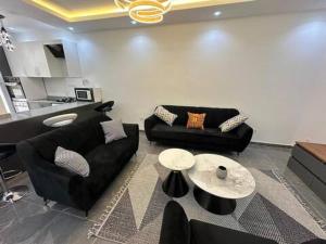 a living room with two black couches and a table at Résidence Elisabeth in Dakar