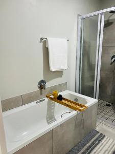un baño con bañera y ducha en Homestead View, en St Francis Bay 7 fotos más