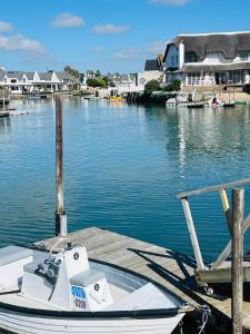 un barco atracado en un muelle en el agua en Homestead View, en St Francis Bay