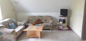 a living room with two couches and a coffee table at Ferienwohnung Eifelglück Hupperath in Hupperath