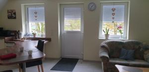 a living room with a couch and a table and windows at Ferienwohnung Eifelglück Hupperath in Hupperath