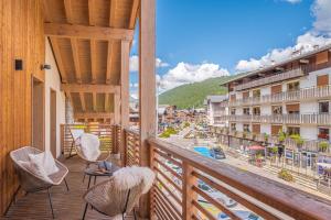 a balcony with chairs and a view of a city at Senna - Center Les GETS spacious & modern in Les Gets