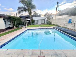 a swimming pool in front of a house at Apartment in Bellville - self-catering in Bellville
