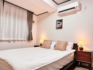 a bedroom with a white bed and a air conditioner at Home Stroy in Tokyo - 1970 Hotel- 江東区門前仲町 2min walk- 東京屋語 in Tokyo
