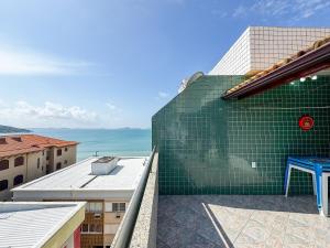a green tile wall on the side of a building at Cobertura Pé na Areia Vista Mar Churrasqueira 12 Pessoas in Arraial do Cabo