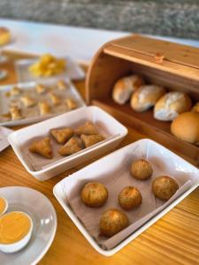 a table with trays of food and a box of biscuits at Pousada Camburi in Morro de São Paulo +66 photos