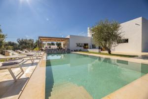 a swimming pool in front of a house at Villa Perla del Mare in Carovigno