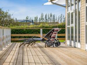 a rocking chair on a porch with a fence at Holiday Home Arton - 300m from the sea by Interhome in Ebberup +22 photos