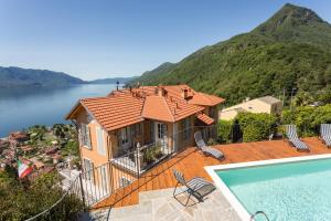 a house with a swimming pool next to a mountain at Villa Paradiso in Cannero Riviera