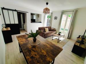 ein Wohnzimmer mit einem Holztisch und einer Couch in der Unterkunft House 64 m2 - 2 bedrooms near Disneyland Paris in Bailly-Romainvilliers