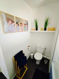 ein Badezimmer mit Toilette und Bildern an der Wand in der Unterkunft House 64 m2 - 2 bedrooms near Disneyland Paris in Bailly-Romainvilliers