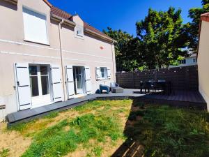 einen Hinterhof eines Hauses mit einer Holzterrasse in der Unterkunft House 64 m2 - 2 bedrooms near Disneyland Paris in Bailly-Romainvilliers