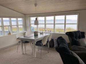 a dining room with a table and chairs and windows at Holiday Home Melia - 50m to the inlet by Interhome in Aabenraa +12 photos