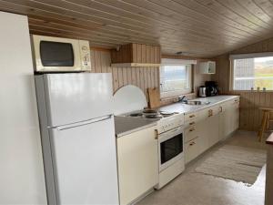 a kitchen with a white refrigerator and a microwave at Holiday Home Melia - 50m to the inlet by Interhome in Aabenraa