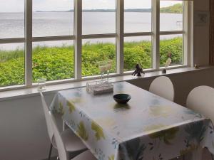 a dining room table with chairs and a view of the ocean at Holiday Home Melia - 50m to the inlet by Interhome in Aabenraa