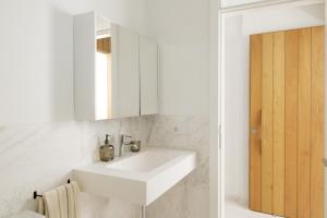 a white bathroom with a sink and a mirror at Ocean Nest by Huskalia in Puerto Naos