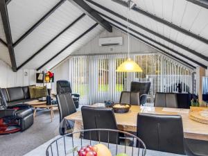 a dining room with tables and chairs and a room with windows at Holiday Home Liljana - 30km from the sea by Interhome in Toftlund