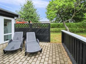 two chairs sitting on a patio next to a fence at Holiday Home Siouxsie - 500m from the sea by Interhome in Esbjerg