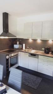 a kitchen with white cabinets and white appliances at Ferienwohnung Sofie Marie in Oberhausen