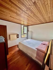 a bedroom with a large bed with a wooden ceiling at Ca'Mugo, a chalet in the magic woods, near Cortina in Vodo Cadore