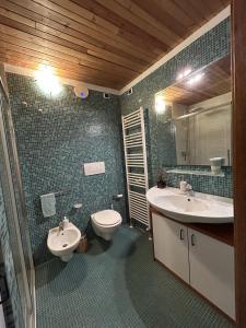 a bathroom with two sinks and a toilet and a mirror at Ca'Mugo, a chalet in the magic woods, near Cortina in Vodo Cadore +66 photos