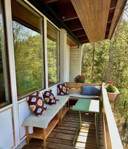 a porch with benches and a table and windows at Ca'Mugo, a chalet in the magic woods, near Cortina in Vodo Cadore