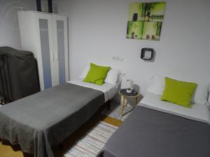 2 Betten in einem Zimmer mit grünen Kissen in der Unterkunft Casasjerezanas VistaFlor in Jerez de la Frontera