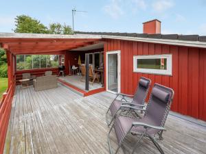 a deck with chairs and a red house at Holiday Home Anline - 900m to the inlet by Interhome in Tarm