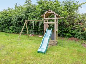 a playground with a slide in the grass at Holiday Home Anline - 900m to the inlet by Interhome in Tarm