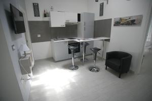 uma cozinha com um balcão e bancos num quarto em Il Portale em Terlizzi