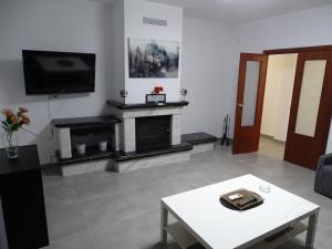 ein Wohnzimmer mit Kamin und Fernseher in der Unterkunft Casasjerezanas VistaFlor in Jerez de la Frontera