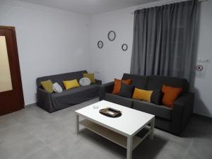ein Wohnzimmer mit zwei Sofas und einem Couchtisch in der Unterkunft Casasjerezanas VistaFlor in Jerez de la Frontera