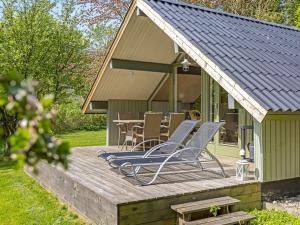 a deck with chairs and a table in front of a house at Holiday Home Hilla - 31km from the sea by Interhome in Toftlund +15 photos