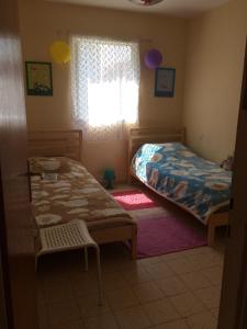 a bedroom with two beds and a window at Apartment on Nitza 8a in Netanya