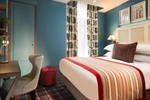 a hotel room with a bed and a desk and a chair at Les Tournelles in Paris