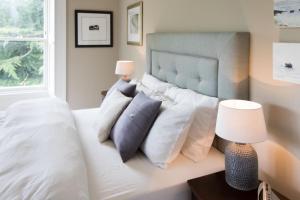 Un dormitorio con una cama blanca con almohadas y una ventana en Newton Farmhouse B & B, en Jedburgh